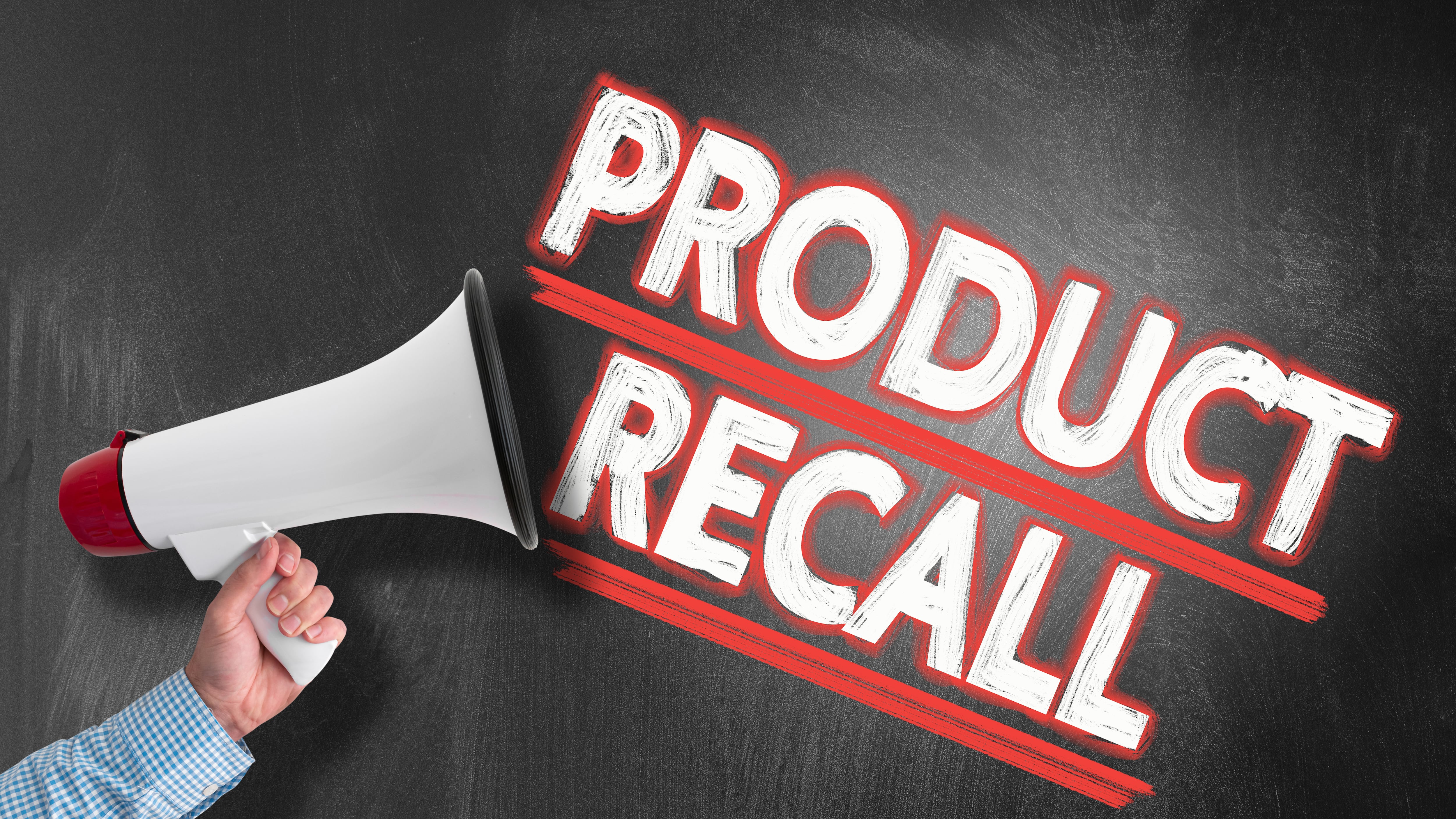 hand holding megaphone or bullhorn against blackboard with text PRODUCT RECALL